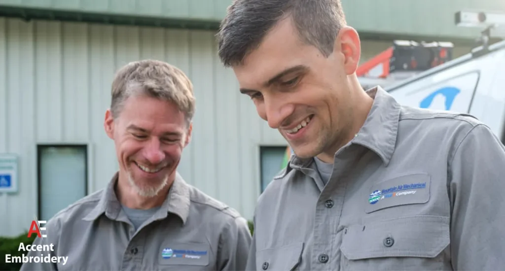 Two men in uniforms happily looking at a computer screen, illustrating teamwork and professionalism in their roles